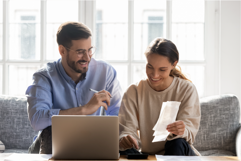 couple sitting on the couch paying their bills using hamilton ebill