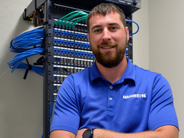 Hamilton employee standing in a Hamilton network closet